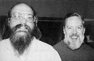 Título: Ken Thompson e Dennis Ritchie em 1973 - Descrição: Fotografia em preto e branco de Ken Thompson e Dennis Ritchie sorrindo lado a lado.