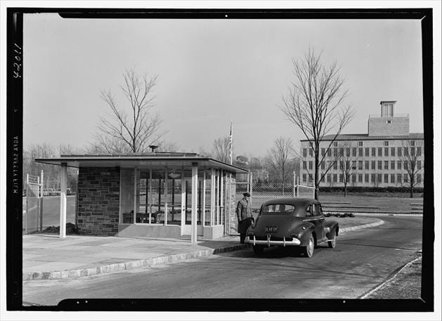 Título: Entrada do laboratório de Murray Hill em 1942 - Descrição: Fotografia em preto e branco da entrada do Bell Telephone Laboratory em Murray Hill, em 1942, com guarita, automóvel e edifícios ao fundo.