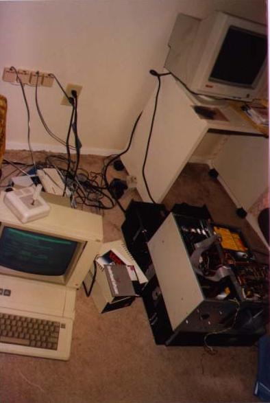 SDF in June 1991: computer parts spread on a table during a move between cases, with the original Apple IIe BBS and a pile of old modems nearby