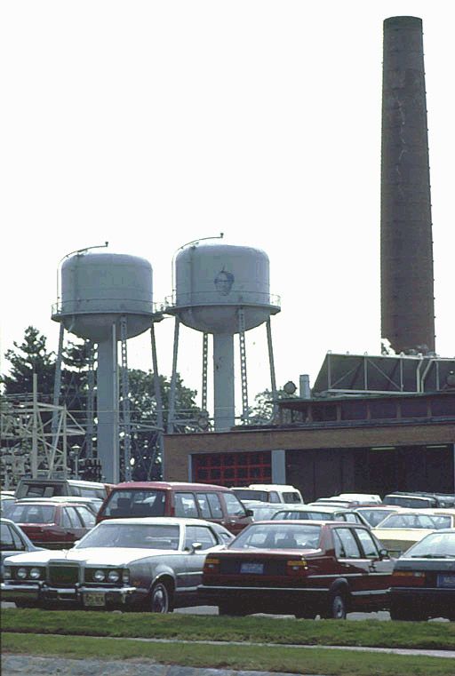 Two water towers beside a parking lot at Bell Labs in 1985, one of them painted with the PJW logo