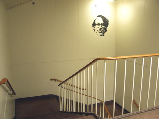 A large PJW face made of small round magnets on the wall of a Bell Labs stairwell